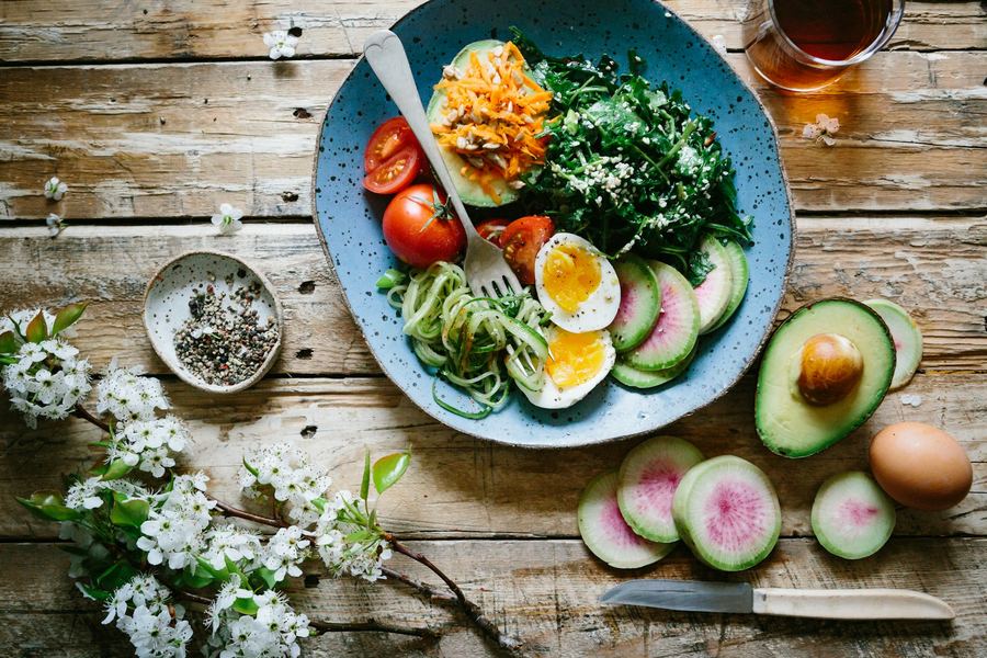 Farfurie cu o masă echilibrată: verdețuri, ou fiert, roșii, avocado și legume proaspete